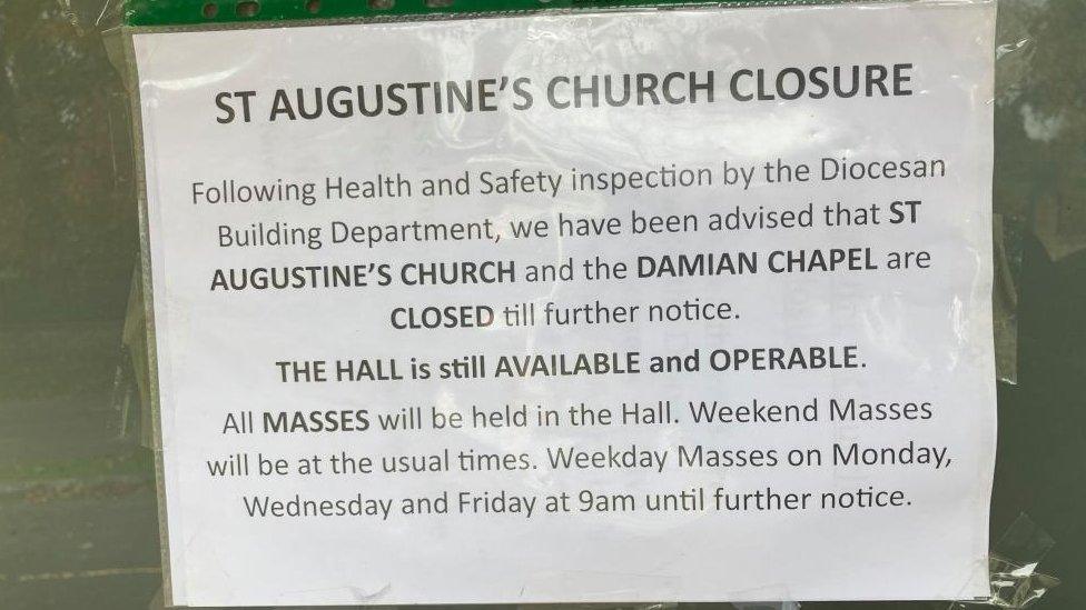 Notice on the front door of the church, advising parishioners that masses will be held in the church hall