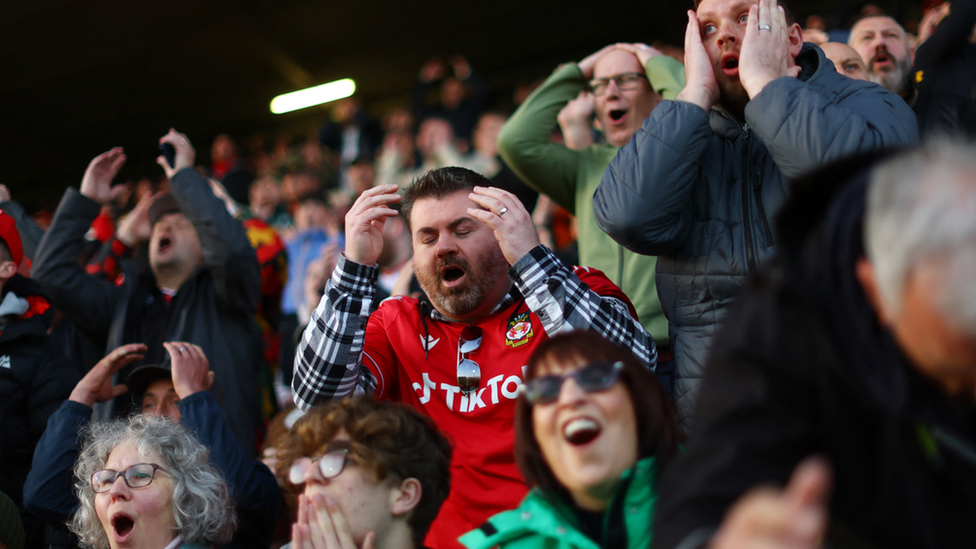 Wrexham fans hold their heads in their hands