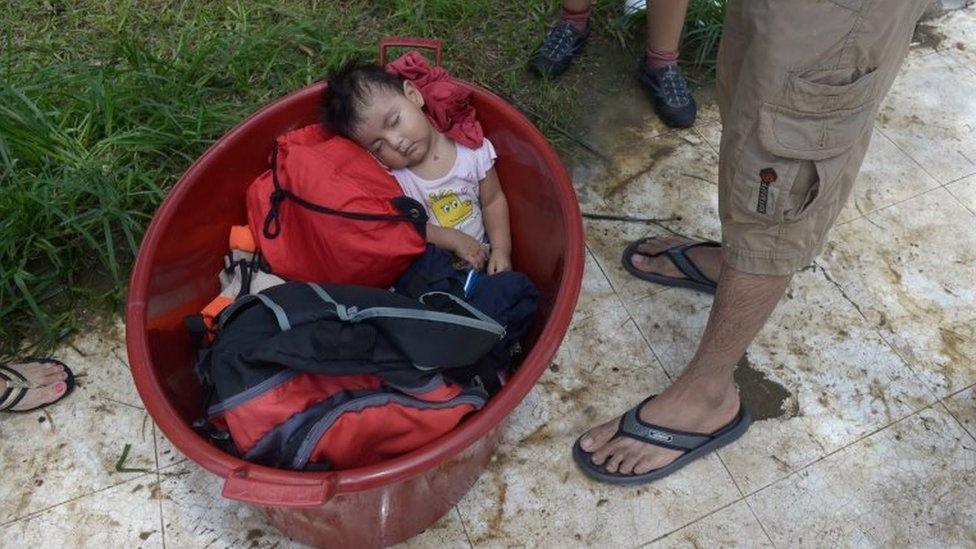 A baby is seen inside a bucket after rivers breached their banks due to torrential rains, causing flooding and widespread destruction in Piura, Peru, March 27, 2017