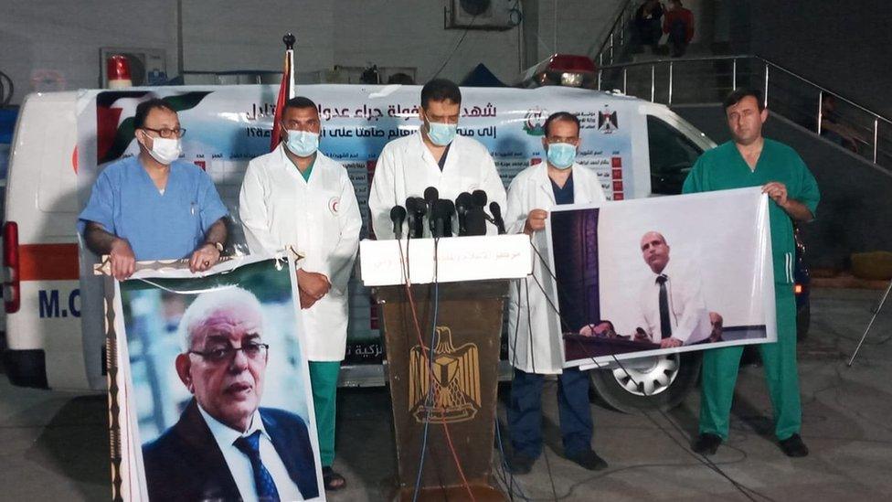 Doctors in Gaza hold up photographs of Mouin al-Aloul (left) and Ayman Abu al-Ouf (right) at a news conference