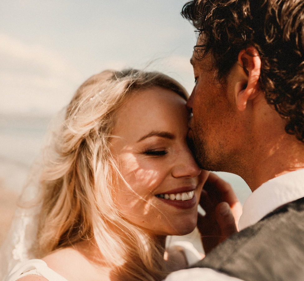 A woman smiling while embracing her new husband