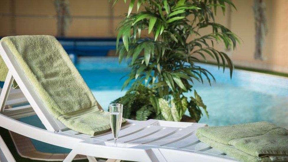 Chair with champagne by swimming pool