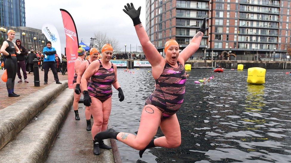 A woman jumps into the water at Salford Quays