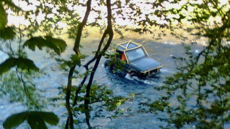 A 4x4 driving through the river Usk