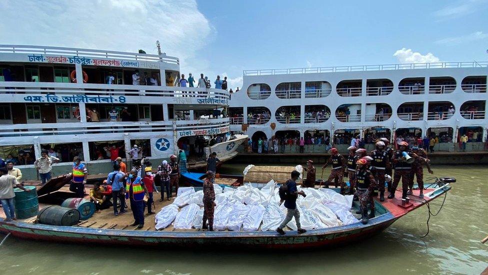 Rescue workers bring bodies of victims after a ferry capsized at the Sadarghat ferry terminal in Dhaka on June 29, 2020.