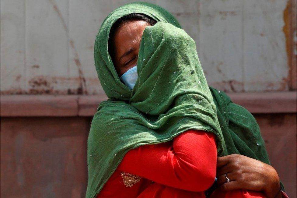 A woman mourns after her father died due to the coronavirus disease (COVID-19) outside a mortuary of a COVID-19 hospital in New Delhi, India, April 15, 2021.