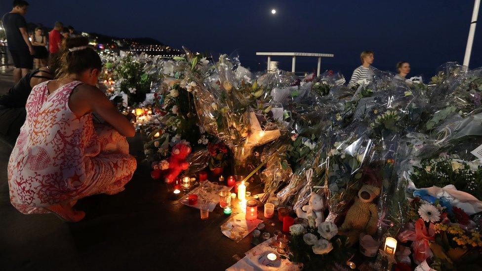 People light candles at a makeshift memorial on the Promenade des Anglais in Nice on July 19, 2016