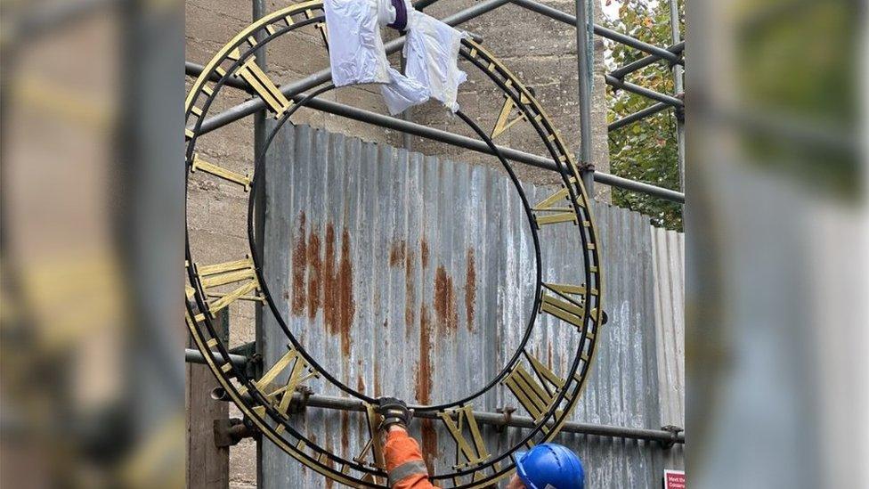 A clock with large gold lettering