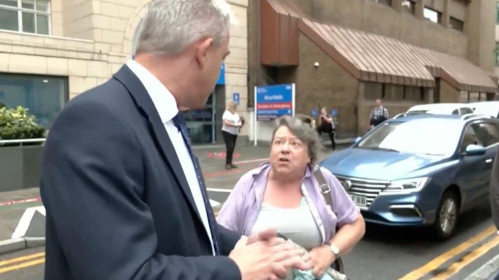 A woman approaches Stephen Barclay outside Moorfields Hospital