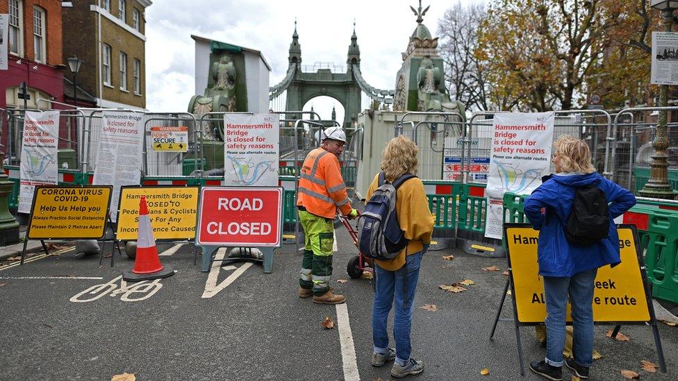 Hammersmith Bridge workman in front of road closure signs