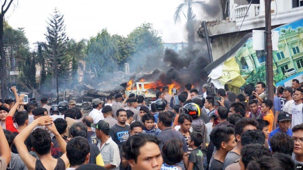 Residents gather next to the crash site (30 June 2015)