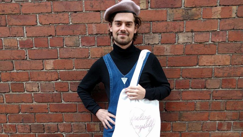 Melbourne hipster Sam Hains poses for a portrait wearing backwards overalls