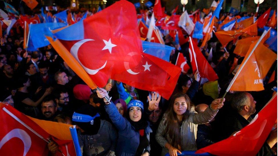 Women wave flags outside the AK Party headquarters in Ankara, Turkey November 1, 2015.