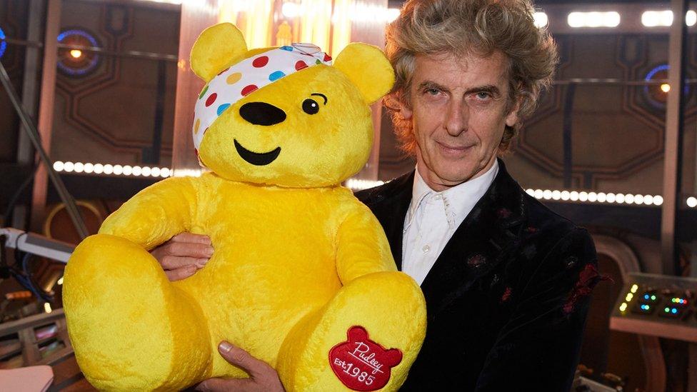 Peter Capaldi holds Pudsey while standing in a studio