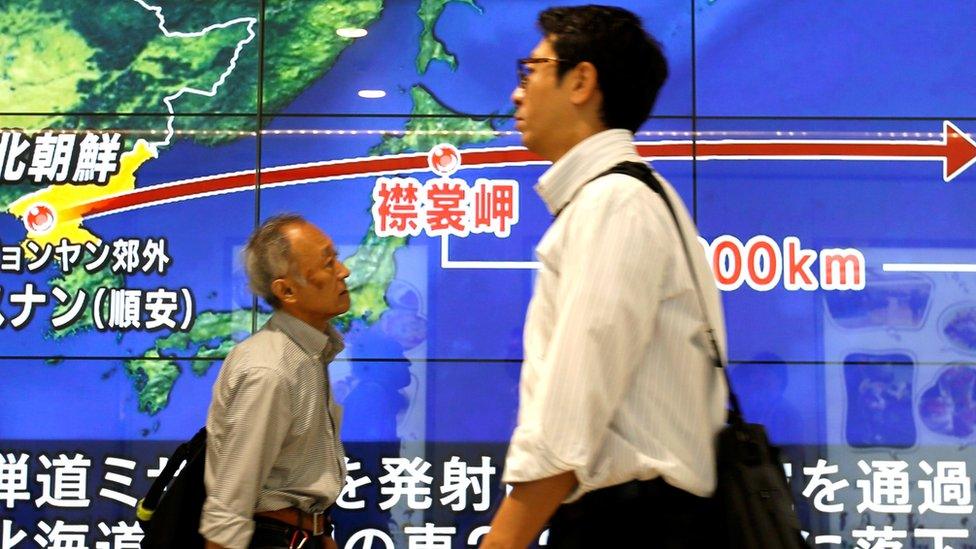 Passersby walk in front of a TV screen reporting news about North Korea"s missile launch, in Tokyo, Japan, September 15, 2017.