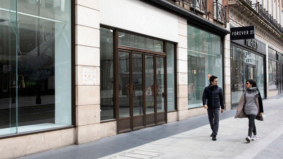 Two people walk down empty High Street