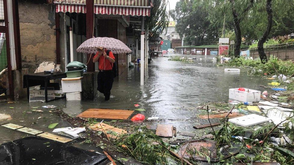 A man wades through floodwaters in the village of Lei Yu Mun during Super Typhoon Mangkhut in Hong Kong on September 16, 2018.