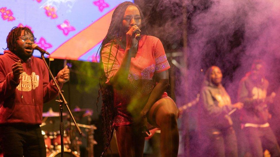 Ugandan musician Cinderella Sanyu (C) performs on stage with her band at Nyege Nyege festival at the Itanda Falls on second day of Nyege Nyege festival, the annual four-day international music festival, in Jinja, on September 16, 2022.