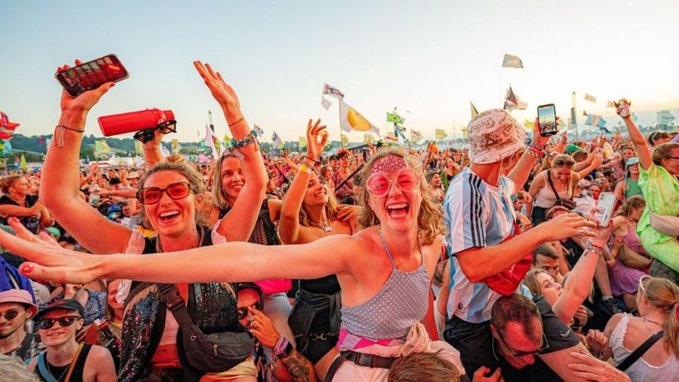 Crowds cheering and dancing at a festival