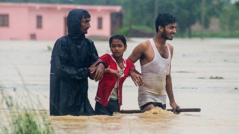 Nepali residents wade along a flood area at Birgunj Parsa district, some 200km south of Kathmandu,