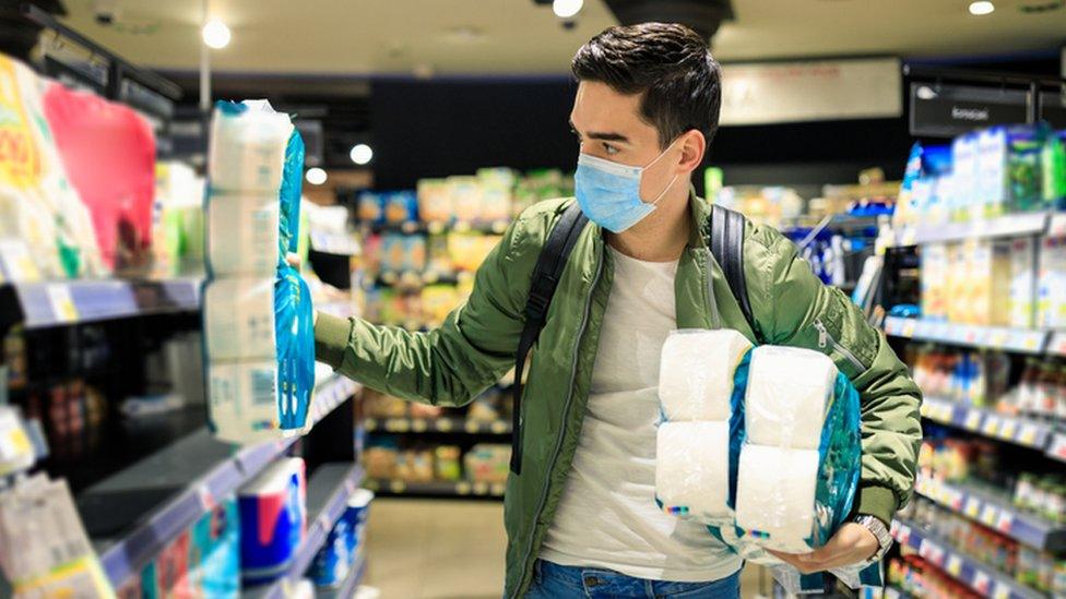 Man buying lots of toilet rolls