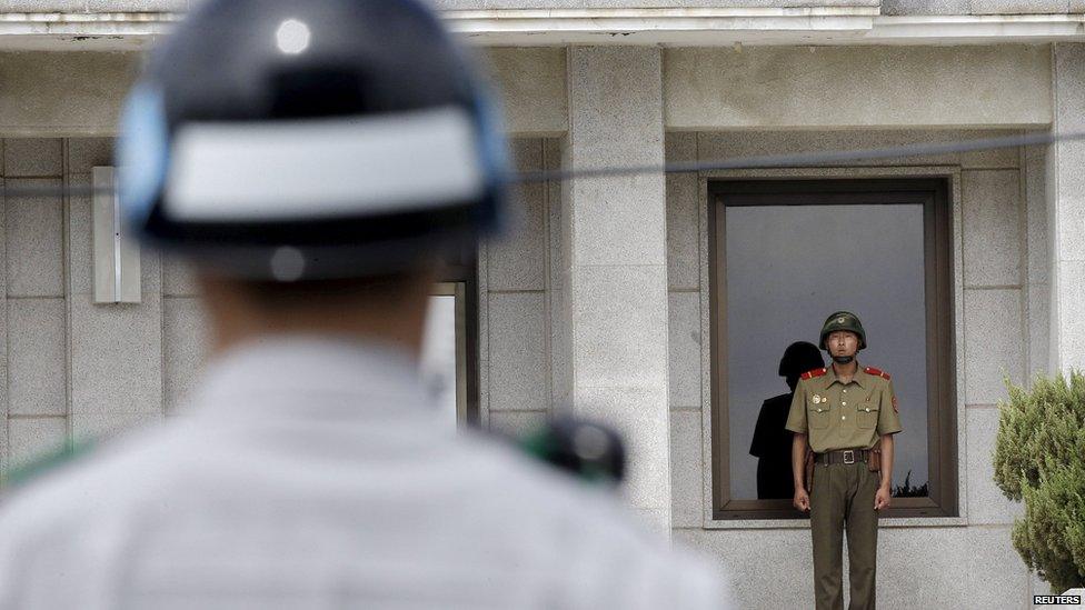 A North (R) and a South Korean army soldier stand guard, in Paju, South Korea, June 26, 2015.