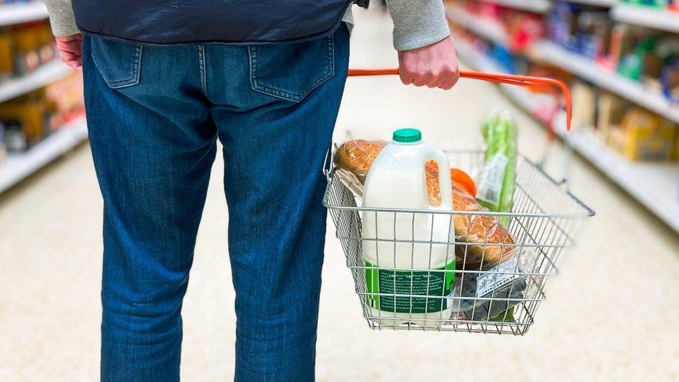 Man holding basket with milk bottle