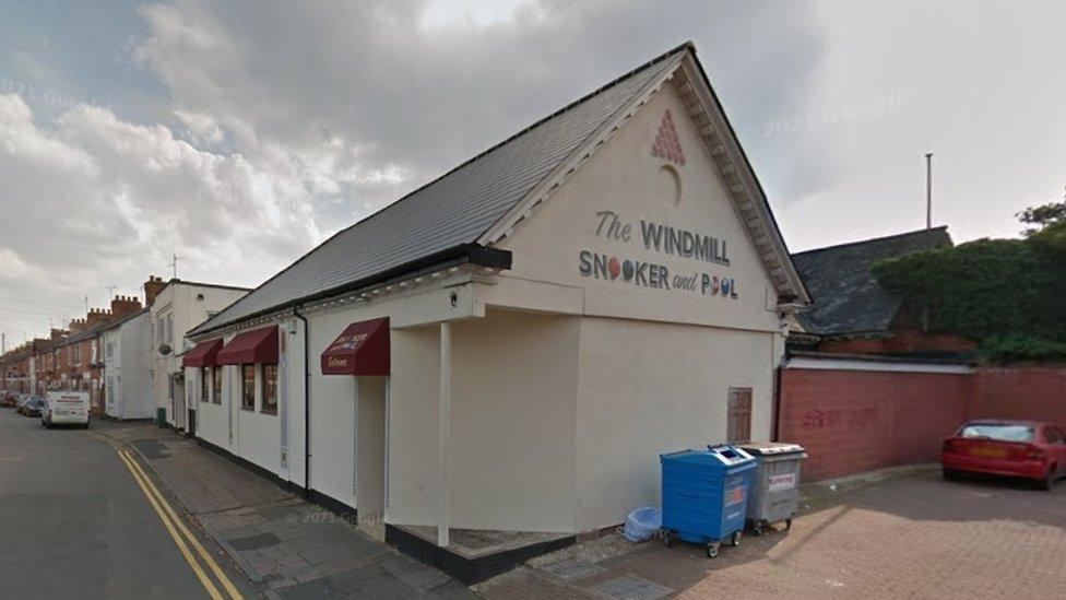 Single-story pitched roof white club in an urban road