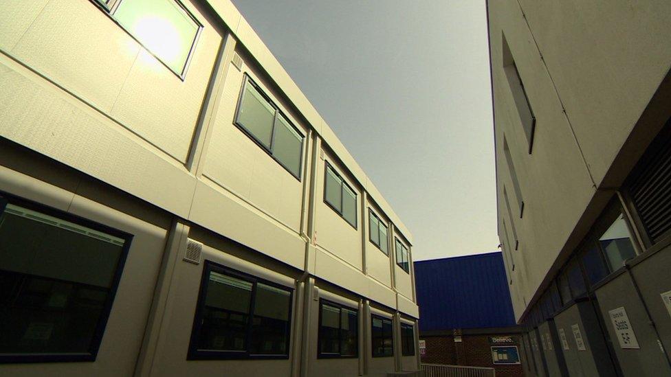 A path surrounded by two rows of multi-storey portable cabins at Park View School.