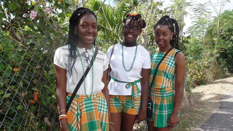 Three girls wearing the national tartan attend the parade