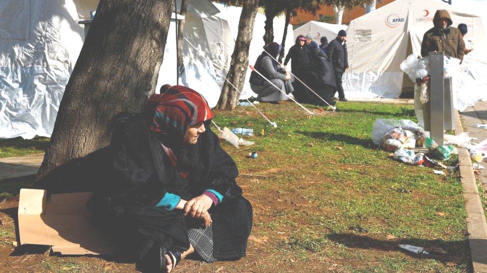 Woman sat outside tents