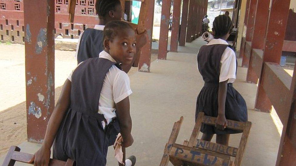 Children dragging chairs to calss