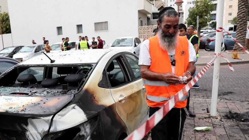 Image shows the aftermath of burned cars after a rocket fired from the Gaza Strip hit Ashdod