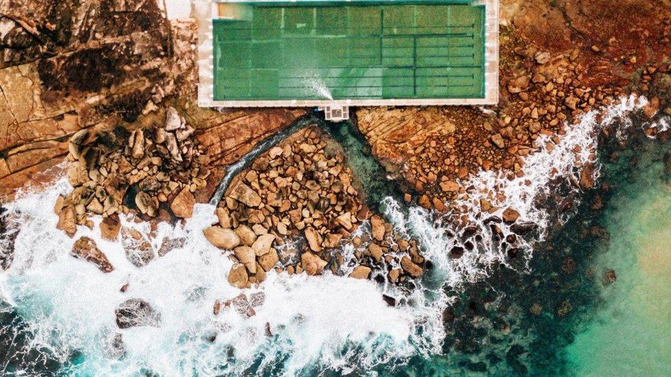 A pool next to the sea from an aerial view