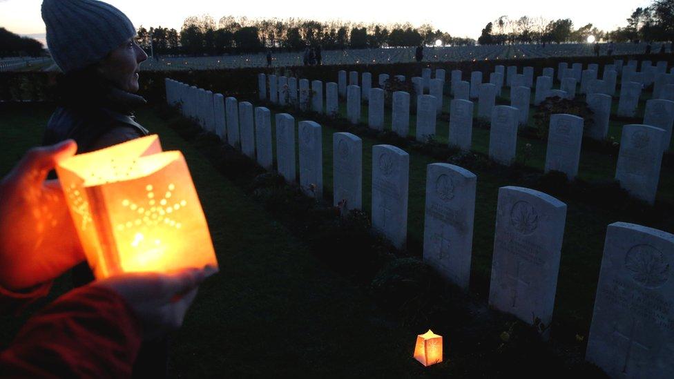 People place candles at the graves of soldiers killed during World War One, at La Targette British Cemetery in Neuville-Saint-Vaast, France, 10 November 2018