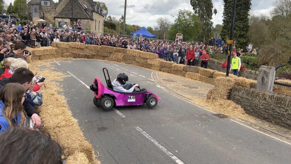 A boy in a purple go-kart