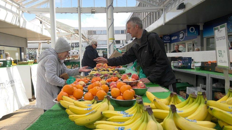 Barry Champion, greengrocer, with a customer