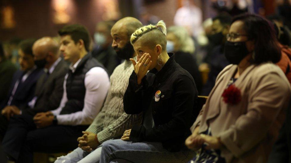 A woman wipes away a tear at the mass