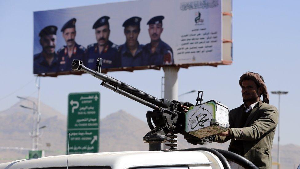 Houthi fighter stands behind a vehicle-mounted machine gun in Sanaa, Yemen (19 December 2018)