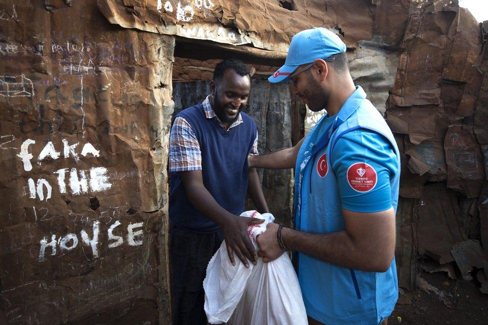 A mans hands out a bag of sacrificial animal meat