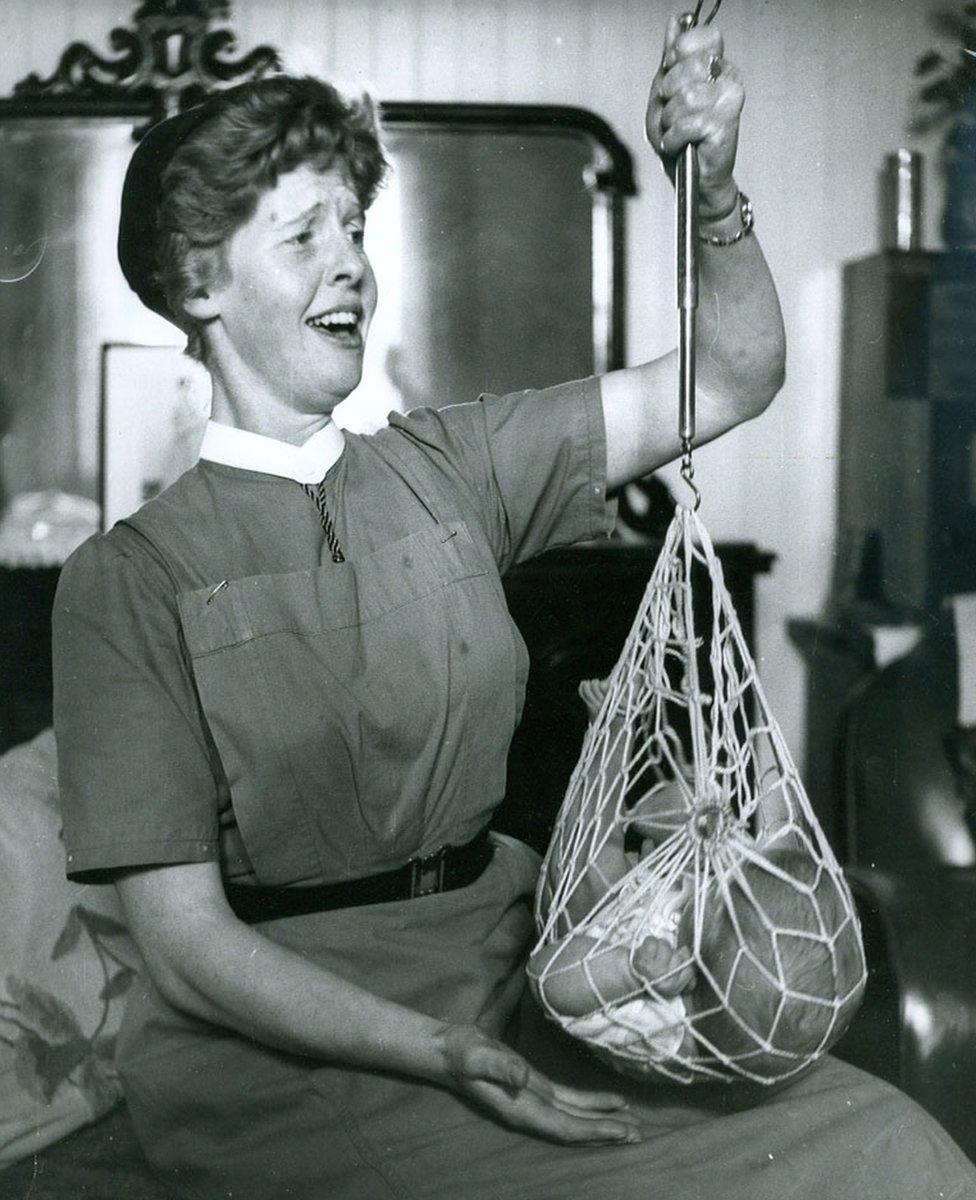 Nurse weighing baby