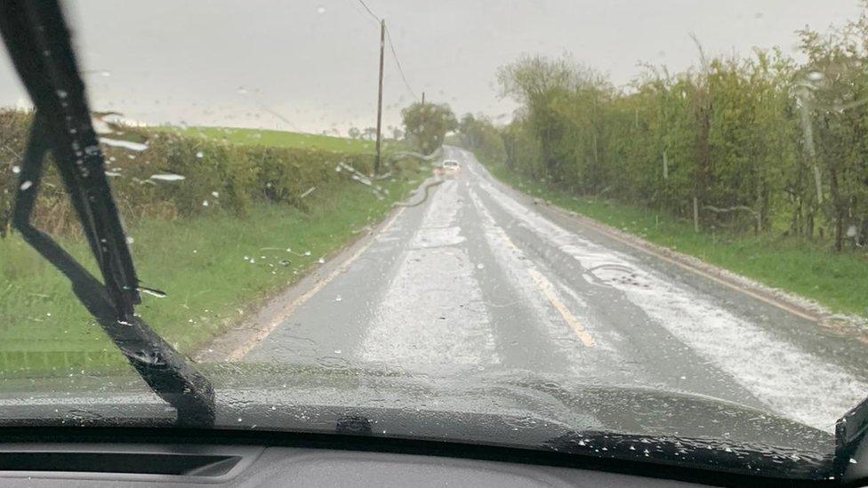 Llyr Jones takes a picture during a hailstorm on his farm in Corwen, North Wales, on Sunday