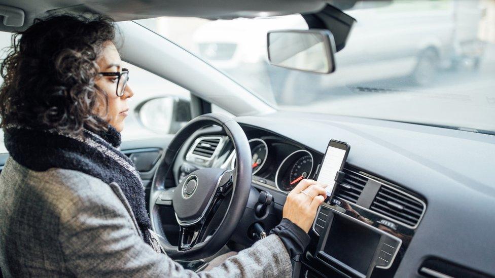 woman in car setting phone