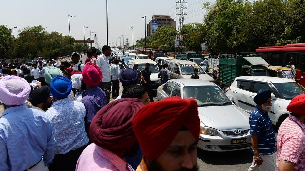 Taxi drivers shout slogans as they block a road during a protest in New Delhi on May 2