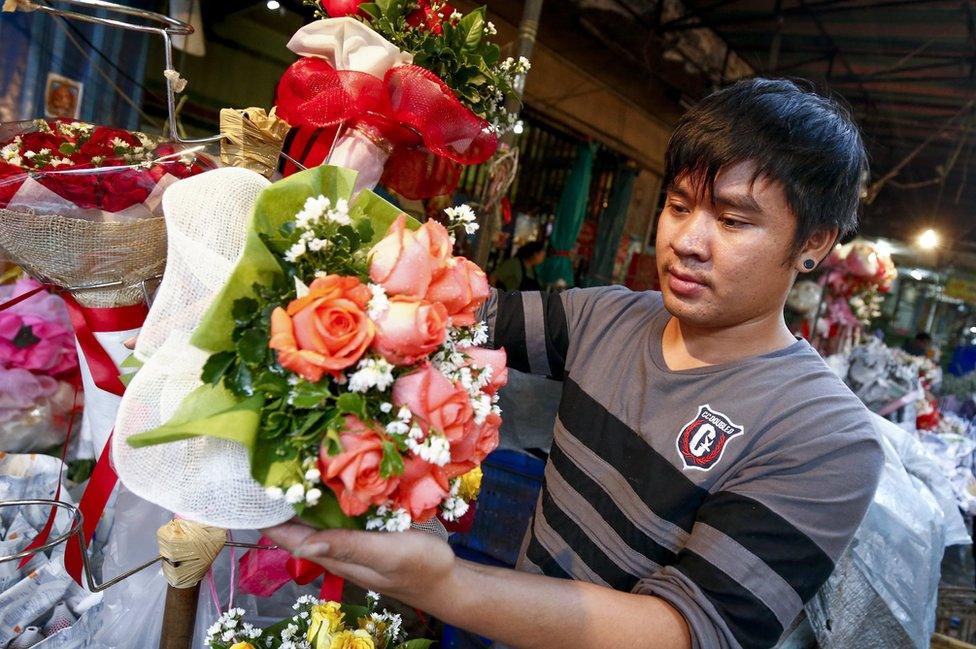 A man prepares an arrangement of roses on Valentine's Day at a flower market in Bangkok, Thailand, on 14 February 2017.