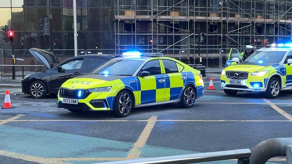 Two police cars surround the collided vehicles