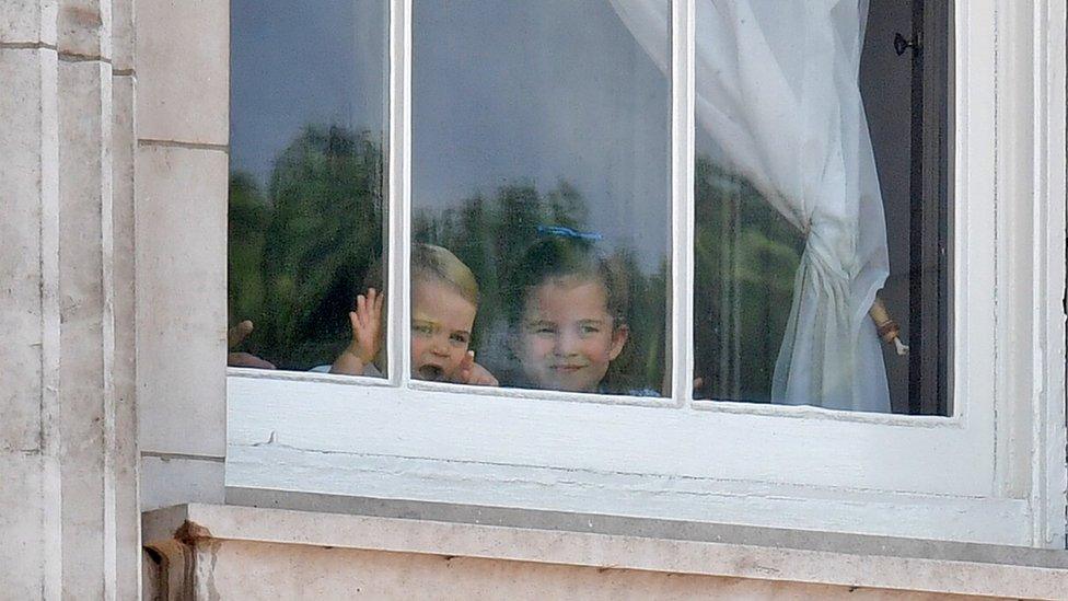 Prince Louis and Princess Charlotte peer out of the windows of Buckingham Palace during the Trooping the Colour parade