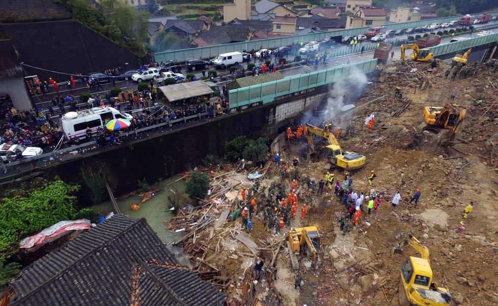 Rescuers dig into the mass of mud