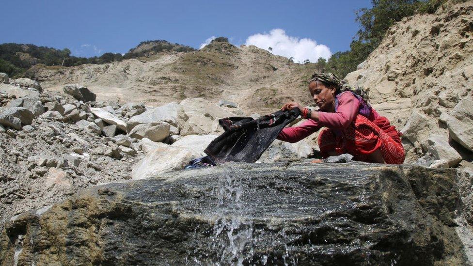 Woman washing clothes by the mountains water in town of Uttarkashi Uttarakhand, India, on 13 October 2018.