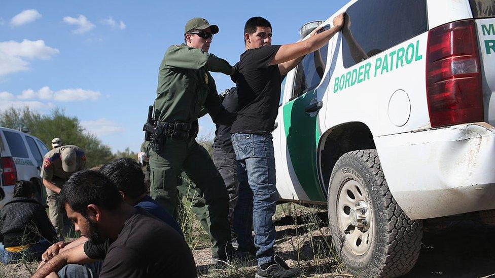 A US Border Patrol officer body searches an undocumented immigrant after he illegally crossed the U.S.-Mexico border